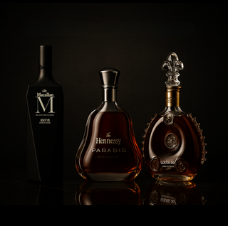 Three bottles of luxury alcohol on a black background