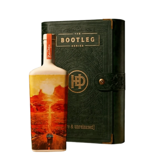 Bottle of whiskey with a decorative label and a black leather case on a white background